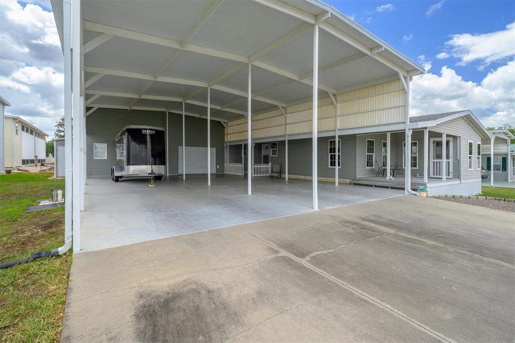 A large metal carport with a concrete floor is attached to the side of a house — 10027 EQUITY AVENUE, DADE CITY, FL