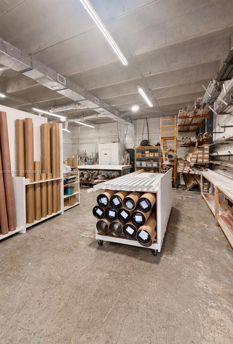 This industrial warehouse space features concrete floors, exposed ceiling ductwork, and various storage racks — 7215 NW 41st St # C, Miami FL 33166, MIAMI, FL