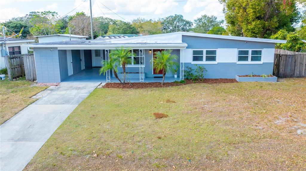 A single-story house with a blue exterior, a carport, and a front lawn — 5320 BRERETON AVENUE, ORLANDO, FL