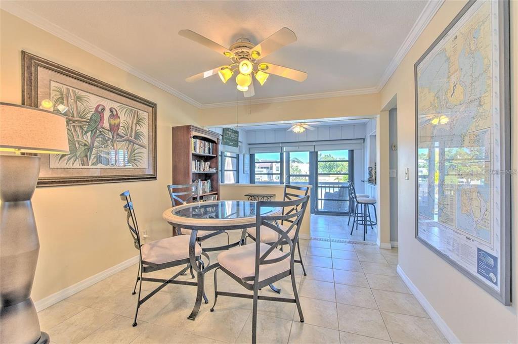 A dining area features a glass-topped table, metal chairs, a ceiling fan, and tiled floors — 1008 APOLLO BEACH BOULEVARD UNIT 201, APOLLO BEACH, FL