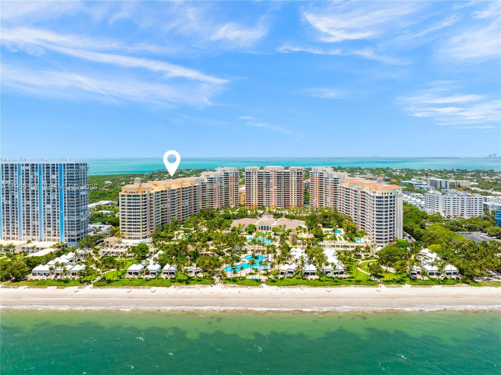 An aerial view shows a large beachfront resort complex with multiple high-rise buildings and pools — 799 Crandon Blvd # 605, Key Biscayne FL 33149, KEY BISCAYNE, FL