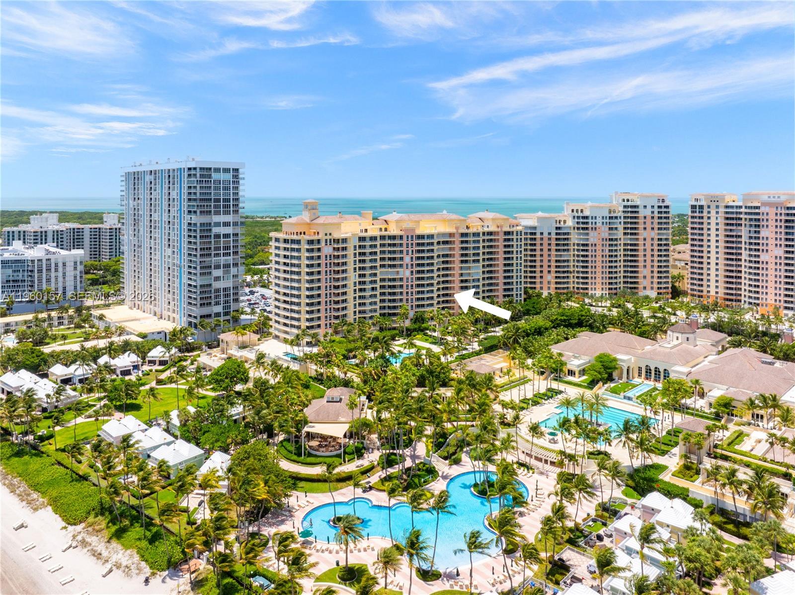 An aerial view shows a large residential complex with multiple pools and lush landscaping — 799 Crandon Blvd # 605, Key Biscayne FL 33149, KEY BISCAYNE, FL