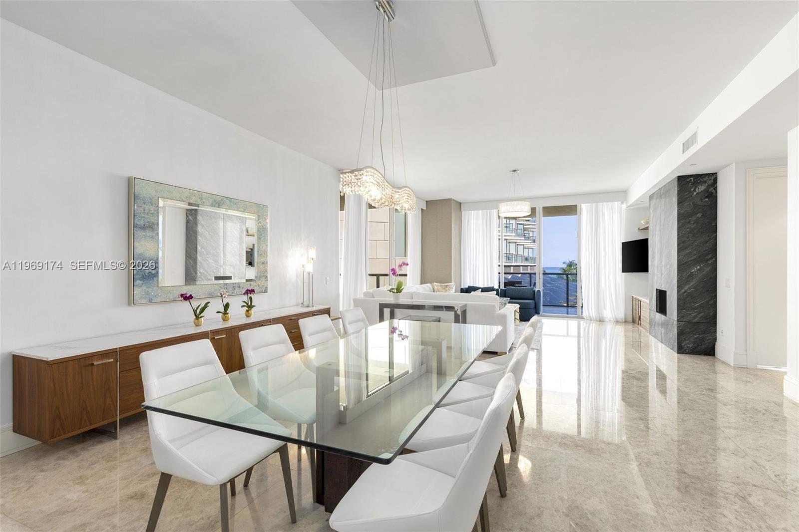 A modern dining room features a glass table, white chairs, and marble flooring — 9701 Collins Ave # 404S, Bal Harbour FL 33154, BAL HARBOUR, FL