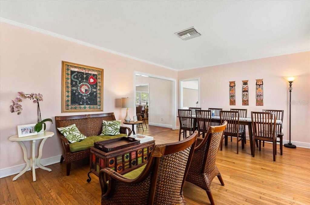 A living and dining area features wicker furniture, hardwood floors, and light pink walls — 2514 15TH AVENUE W, BRADENTON, FL