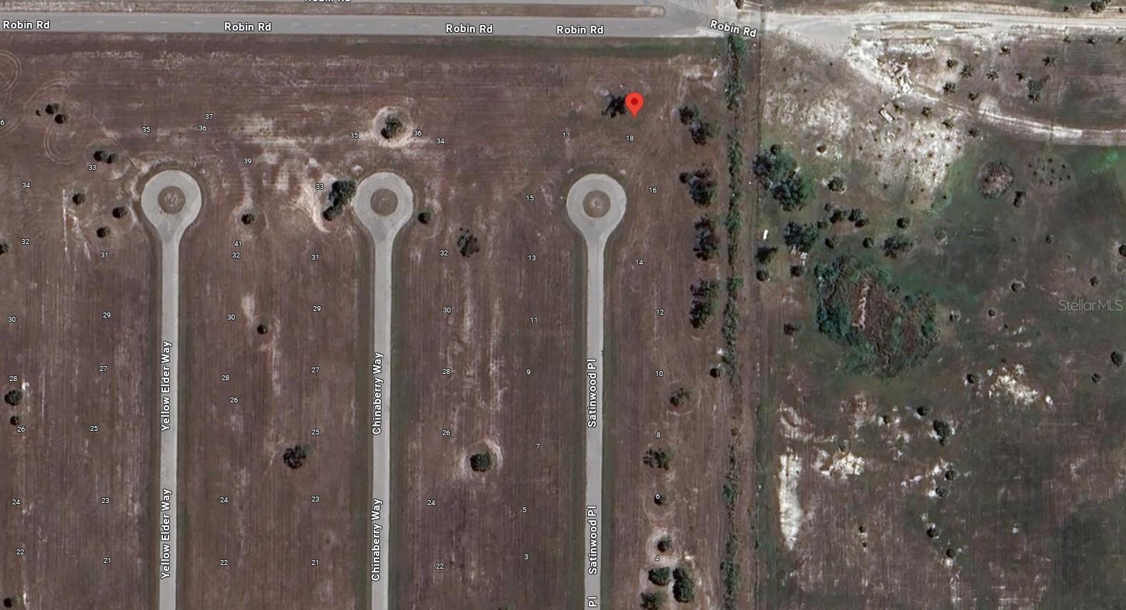 This is a satellite map view of a residential subdivision with undeveloped lots and streets — 18 Satinwood Place, FL 33946, FL