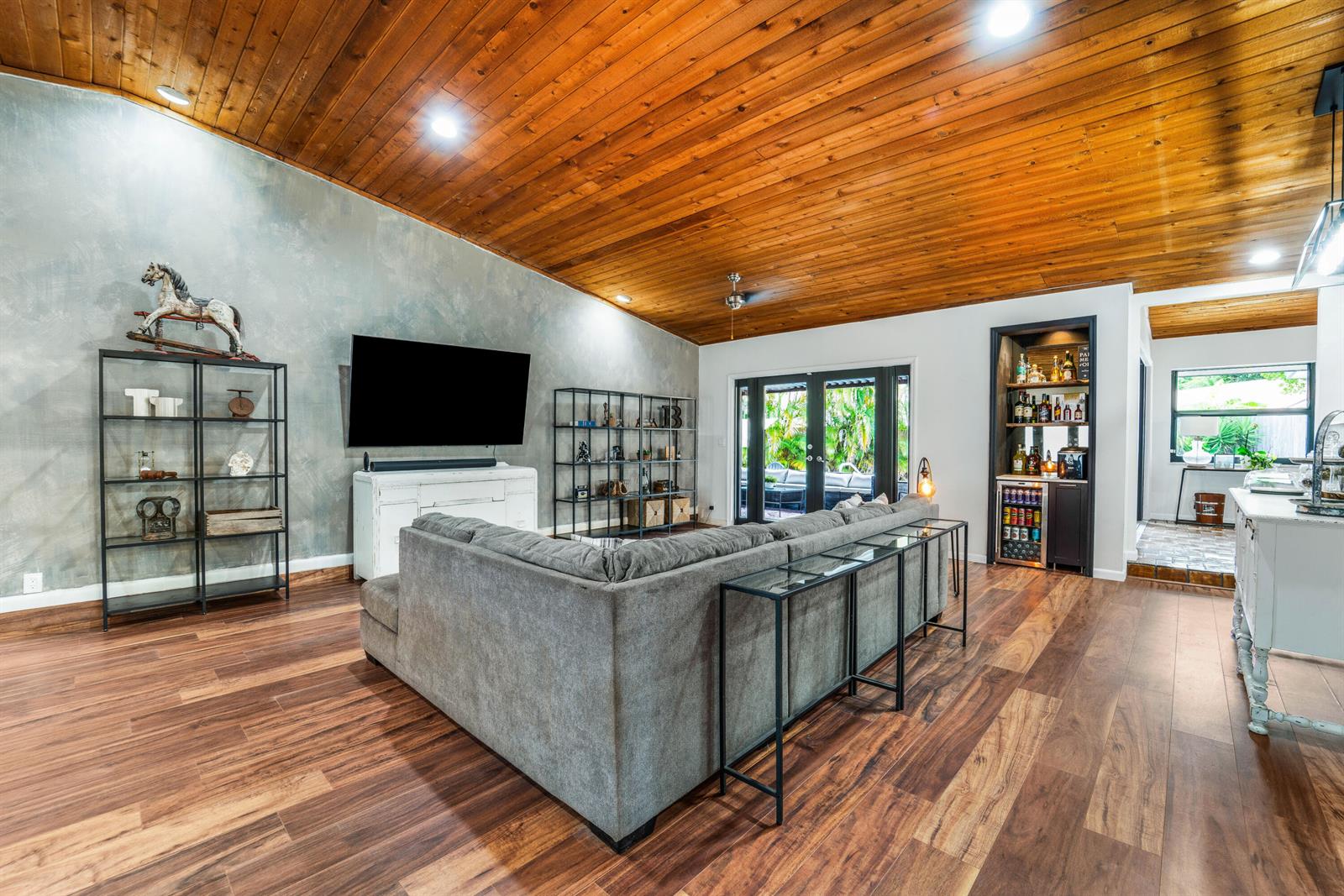 A living room features a vaulted wood ceiling, gray accent wall, and a sectional sofa — 5731 NW 54th Way, Tamarac FL 33319, TAMARAC, FL