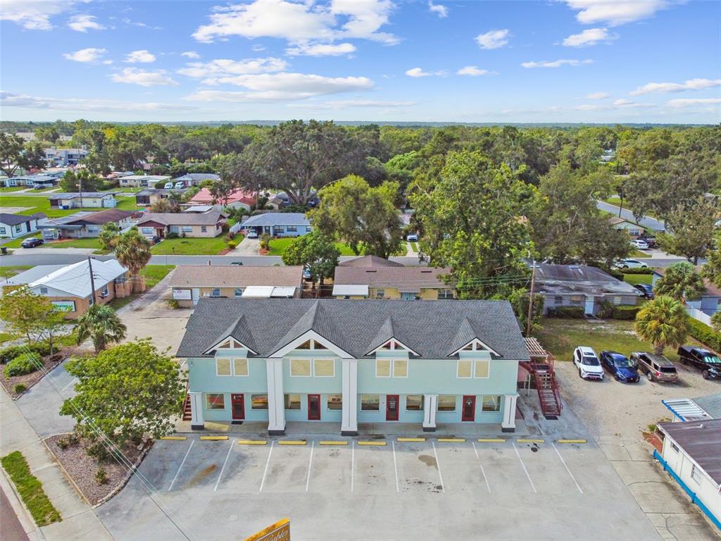 An aerial view shows a light green commercial building with a parking lot in front — 1137 BARTOW ROAD UNIT 204, LAKELAND, FL