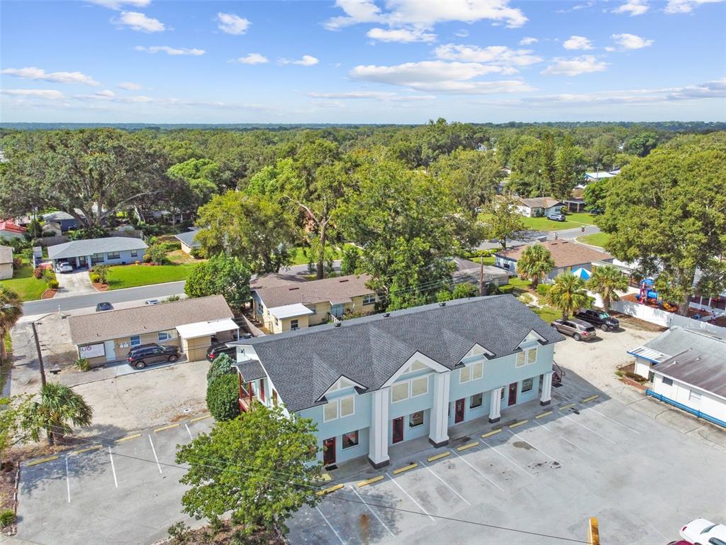 An aerial view shows a multi-unit residential building with a parking lot and surrounding trees — 1137 BARTOW ROAD UNIT 204, LAKELAND, FL