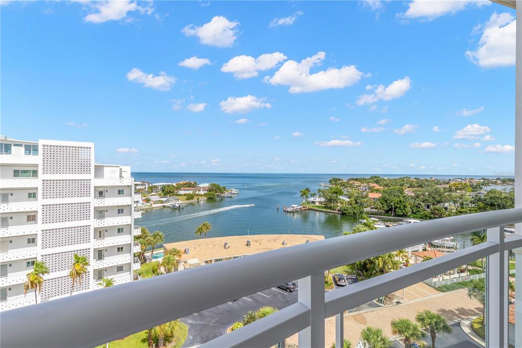 A high-angle view from a balcony overlooking a waterway, coastal homes, and the ocean — 1325 SNELL ISLE BOULEVARD NE UNIT 812, ST PETERSBURG, FL