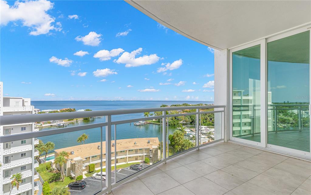 A balcony with tile flooring overlooks a bay, nearby buildings, and a parking lot — 1325 SNELL ISLE BOULEVARD NE UNIT 812, ST PETERSBURG, FL