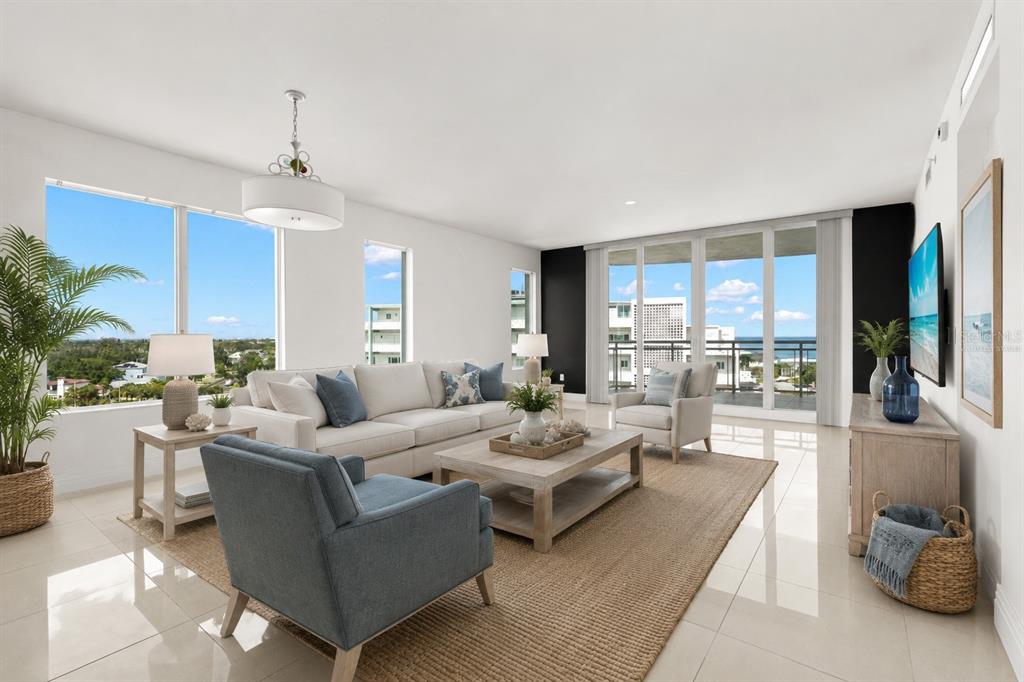 A bright living room features a white sofa, blue armchairs, and floor-to-ceiling windows with views — 1325 SNELL ISLE BOULEVARD NE UNIT 812, ST PETERSBURG, FL