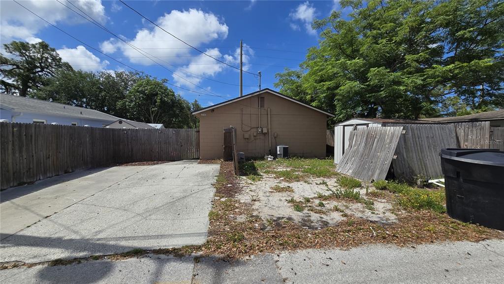 A concrete driveway leads to the rear of a house with a damaged wooden fence — 3743 1ST AVENUE S, ST PETERSBURG, FL