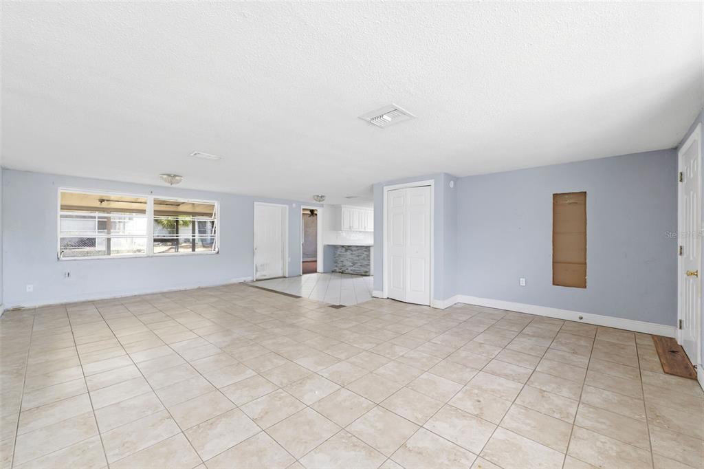 A white stucco house exterior features a gated courtyard entrance with a palm tree — 9720 RAINBOW LANE, PORT RICHEY, FL