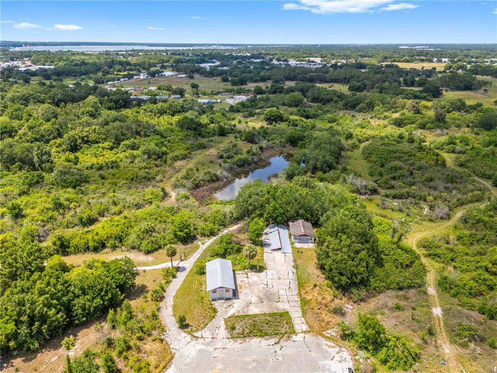 An aerial view shows a rural property with two small buildings, a pond, and vegetation — 1100 SKYVIEW BOULEVARD UNIT 1, LAKELAND, FL