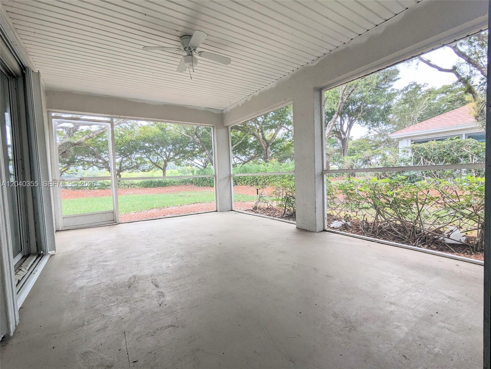 A screened-in porch with a concrete floor, white ceiling, and a ceiling fan — 532 SE 21st Dr, Homestead FL 33033, HOMESTEAD, FL