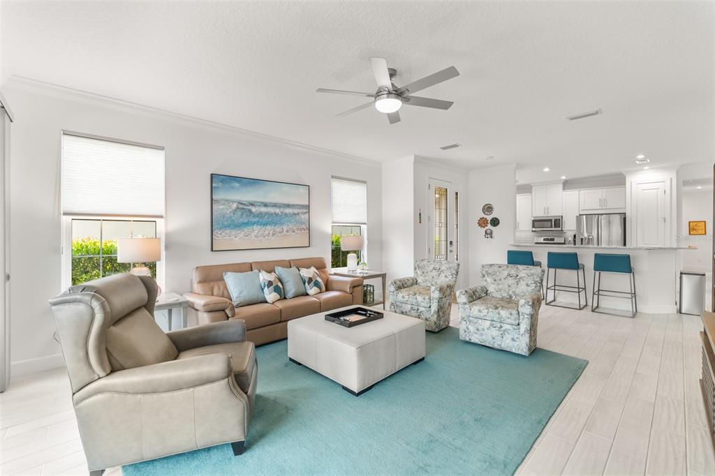 A living room with a beige sofa, two patterned armchairs, and a teal area rug — 5362 CICERONE STREET, SARASOTA, FL
