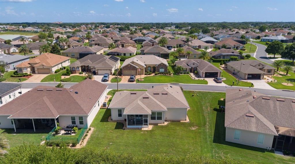 A single-story house with a beige stucco exterior, a two-car garage, and a landscaped yard — 10949 SE 169TH LANE, SUMMERFIELD, FL