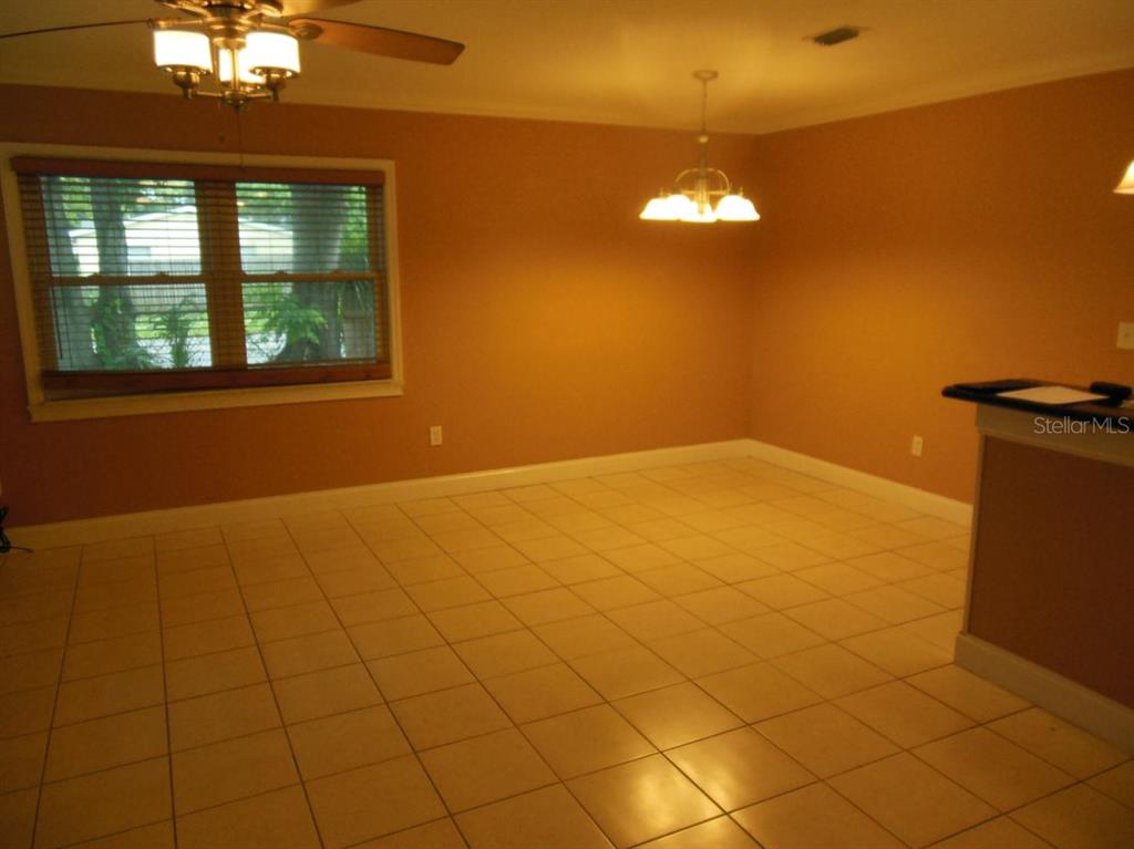 A dining area with tan walls, light-colored tile flooring, a ceiling fan, and a pendant light — 13423 121ST STREET, SEMINOLE, FL