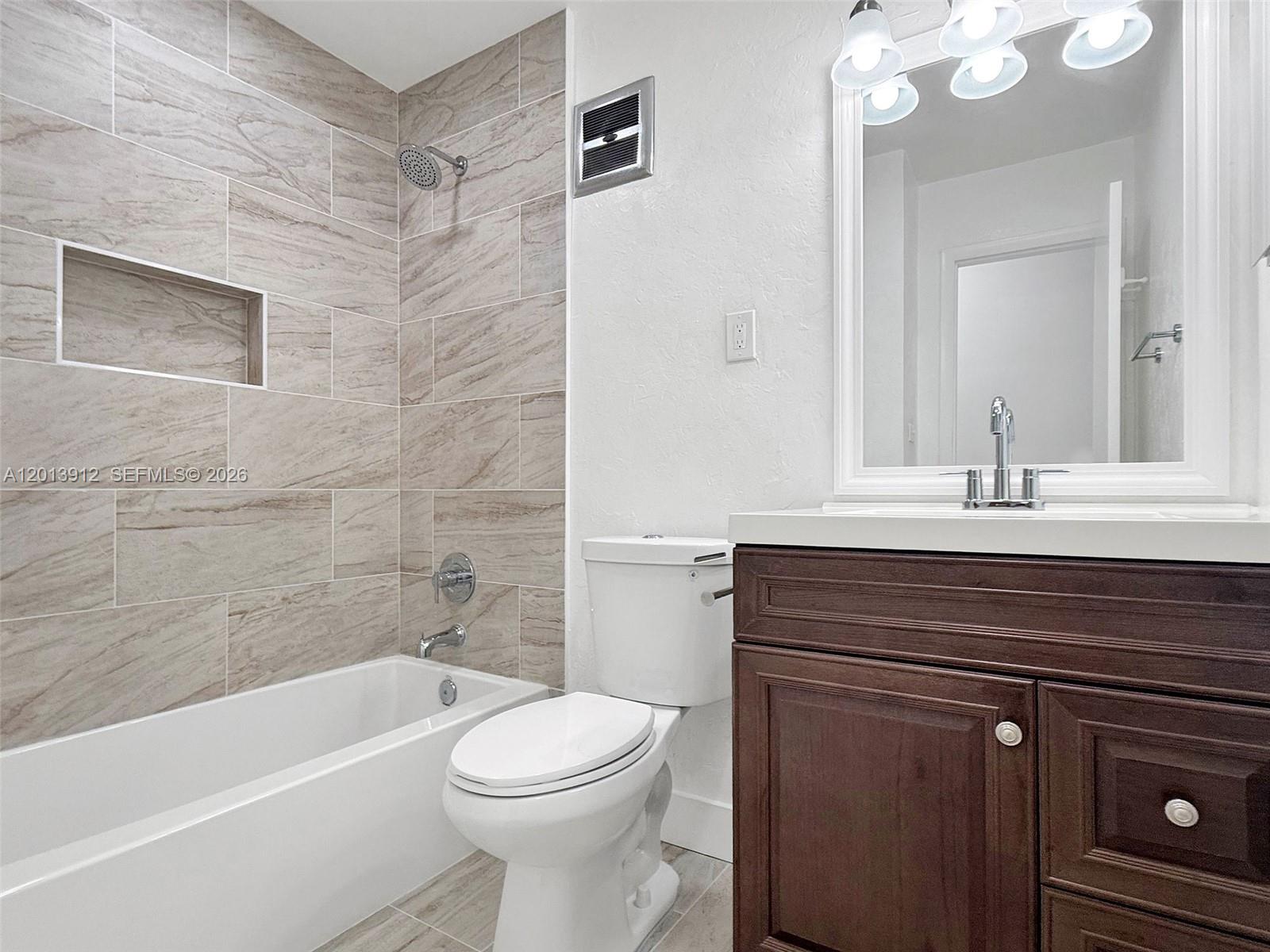 A bathroom features a tiled tub-shower combination, a white toilet, and a dark wood vanity — 3045 SW 124th Ct, Miami FL 33175, MIAMI, FL