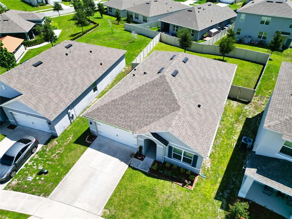 An aerial view shows a suburban house with a gray shingled roof and driveway — 11244 AMBER RIDGE DRIVE, ZELLWOOD, FL