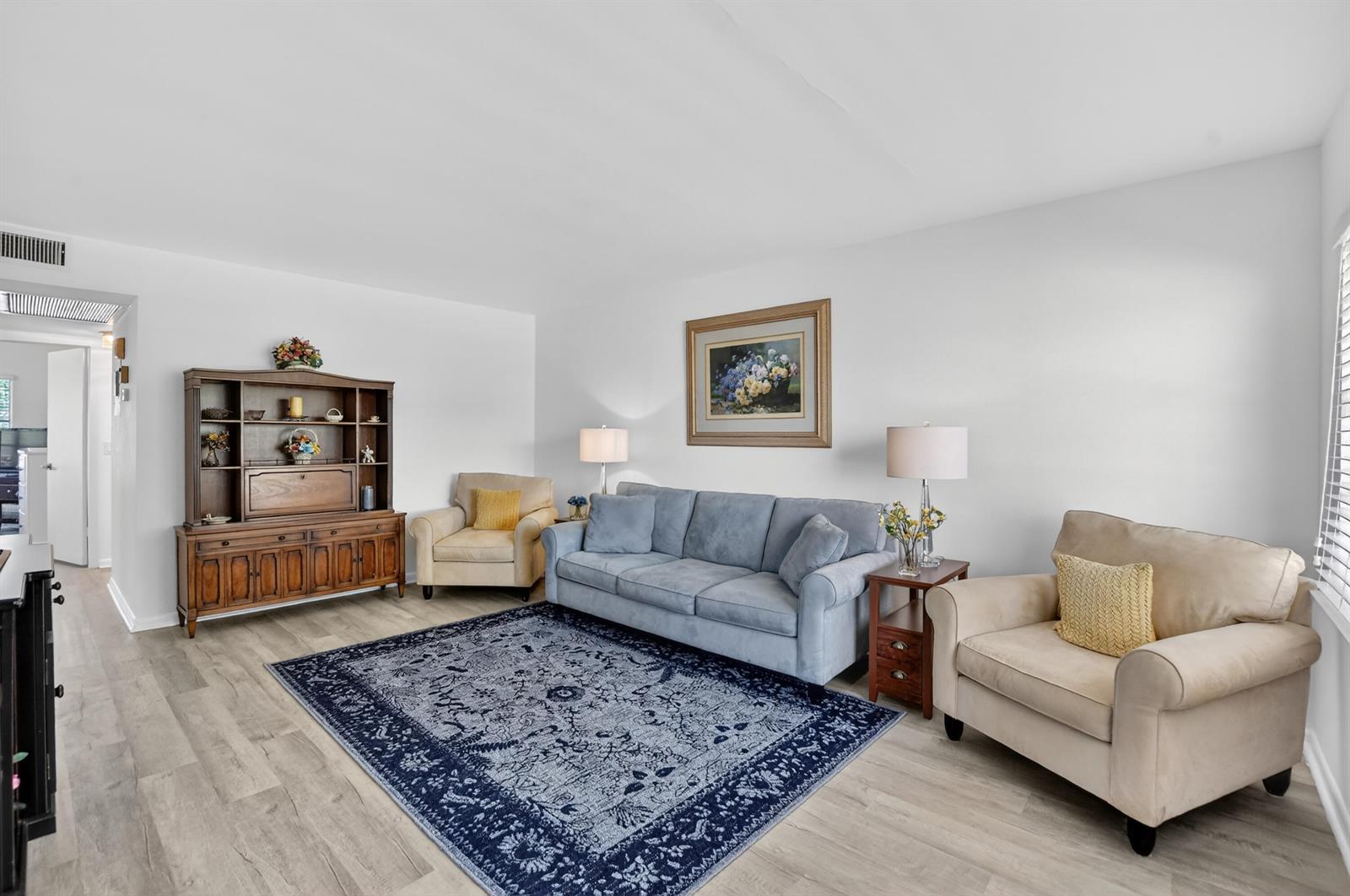A living room features a blue sofa, two beige armchairs, and a wooden hutch — 150 Mansfield D # 150, Boca Raton FL 33434, BOCA RATON, FL