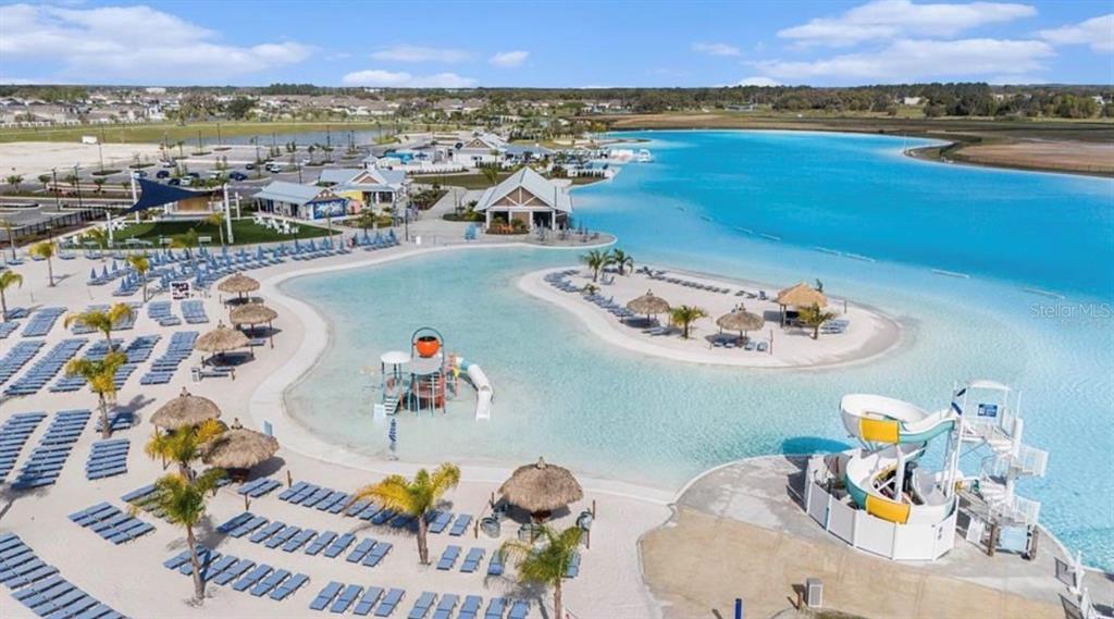 An aerial view shows a large swimming lagoon with a water slide and lounge chairs — 31406 MANGO FADE WAY, SAN ANTONIO, FL