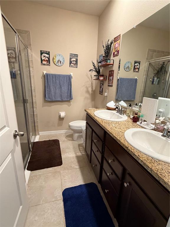 A bathroom features a double vanity with granite countertops, dark wood cabinets, and a shower — 31406 MANGO FADE WAY, SAN ANTONIO, FL