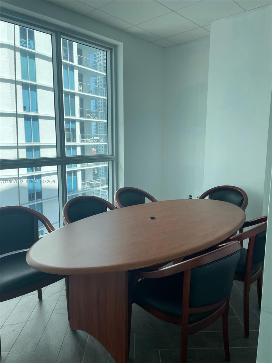 A conference room features an oval wooden table, dark chairs, and floor-to-ceiling windows — 175 SW 7th St # 2102, Miami FL 33130, MIAMI, FL