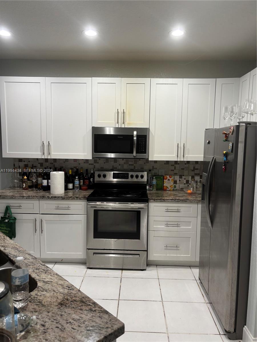 A kitchen features white cabinets, stainless steel appliances, and a granite countertop — 3544 Dunes Vista Dr, Pompano Beach FL 33069, POMPANO BEACH, FL