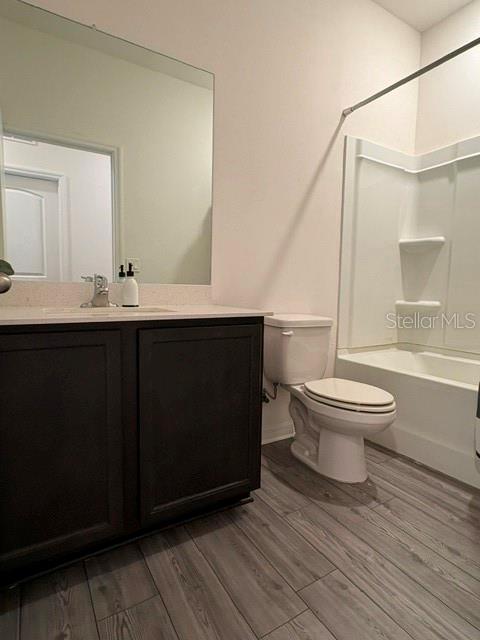 A bathroom features a dark wood vanity, a large mirror, and a shower-tub combination — 2119 NW 23RD TERRACE, CAPE CORAL, FL