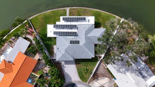 An aerial view shows a house with solar panels on the roof near a lake — 7800 4TH AVENUE S, ST PETERSBURG, FL