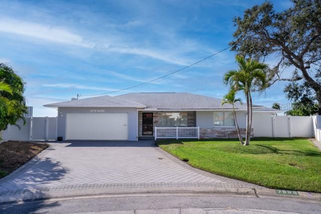 A single-story house with a paved driveway, a two-car garage, and a palm tree — 7800 4TH AVENUE S, ST PETERSBURG, FL