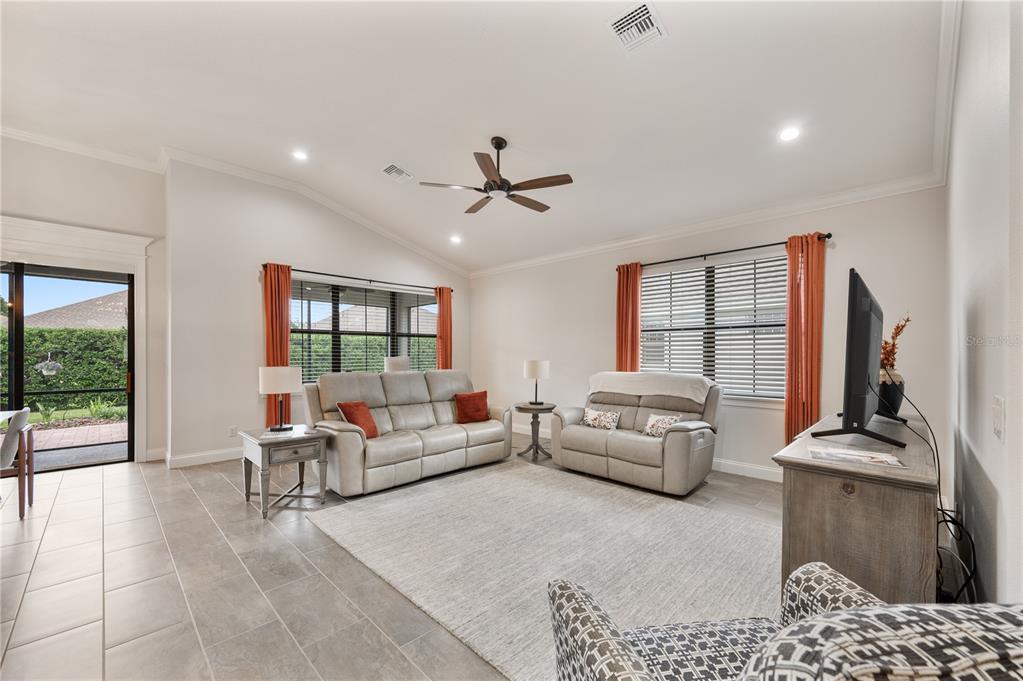 A living room features light tile floors, a ceiling fan, and two neutral-colored sofas — 7783 LAKE JAMES BOULEVARD, LAKELAND, FL