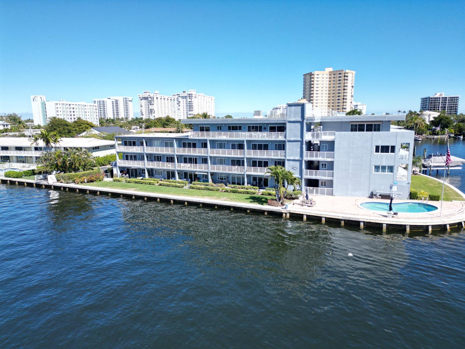 An aerial view of a multi-story apartment building with a pool along the waterfront — 1201 S Riverside Drive # 208, Pompano Beach FL 33062, POMPANO BEACH, FL