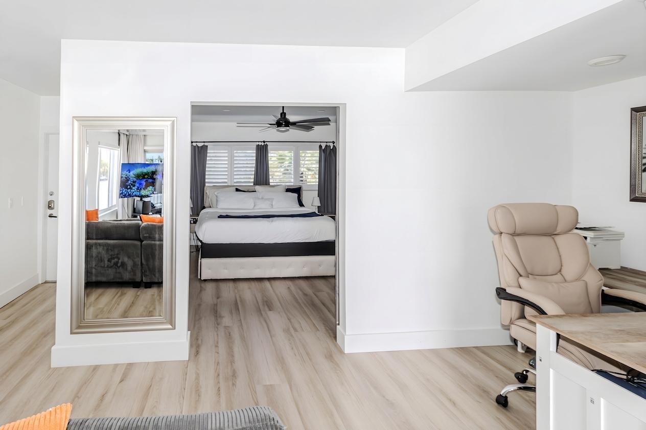 A home office area opens into a bedroom with a bed and ceiling fan — 1201 S Riverside Drive # 208, Pompano Beach FL 33062, POMPANO BEACH, FL