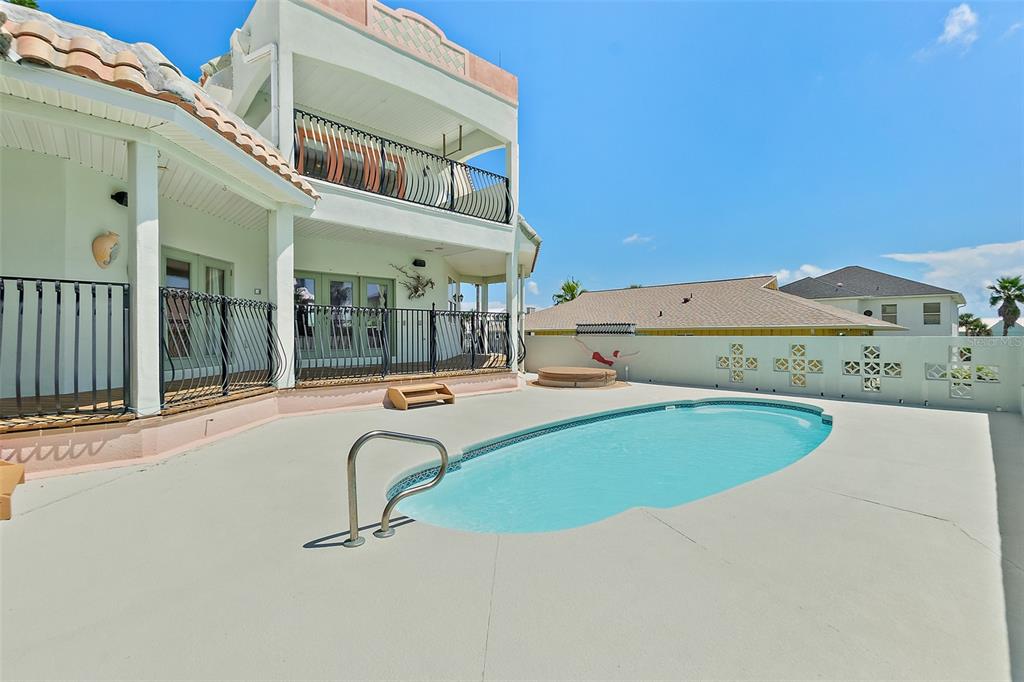 A two-story house with a balcony overlooks a backyard swimming pool and a concrete patio — 54 OCEAN ST, PALM COAST, FL