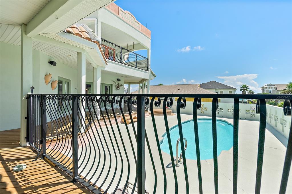 A view from a wooden deck overlooking a swimming pool and a multi-story house — 54 OCEAN ST, PALM COAST, FL