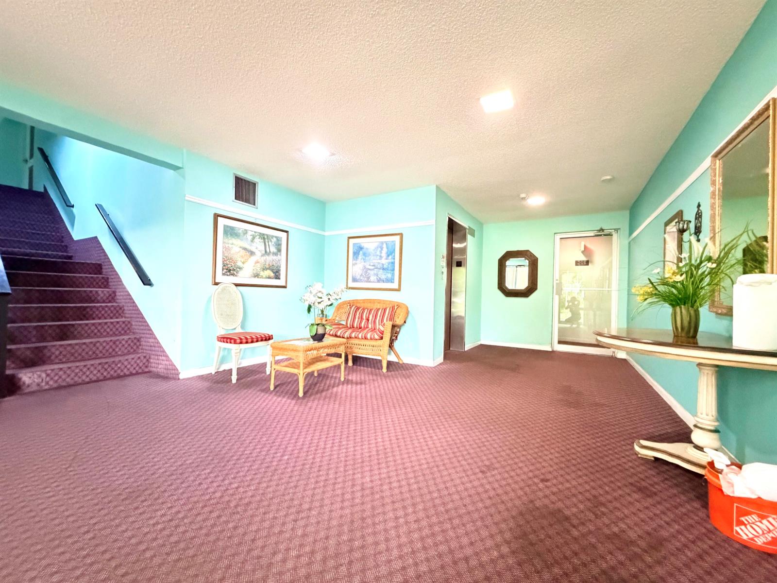 A carpeted building lobby features light blue walls, a staircase, seating, and an elevator — 5180 E Sabal Palm Boulevard # 228, Tamarac FL 33319, TAMARAC, FL