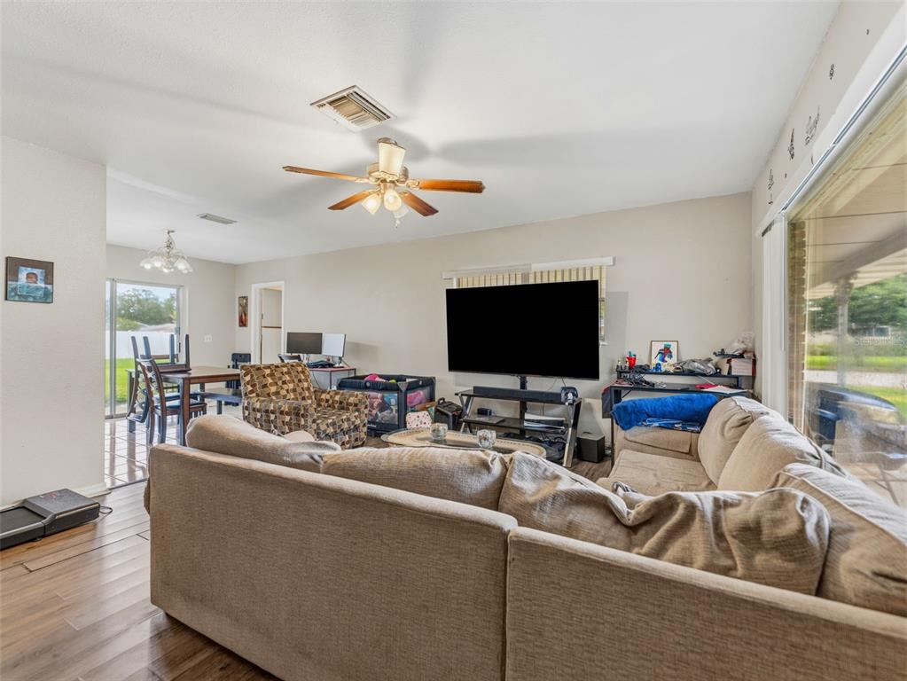 A living room with a large sectional sofa, a television, and an adjacent dining area — 2109 W ERNA DRIVE, TAMPA, FL