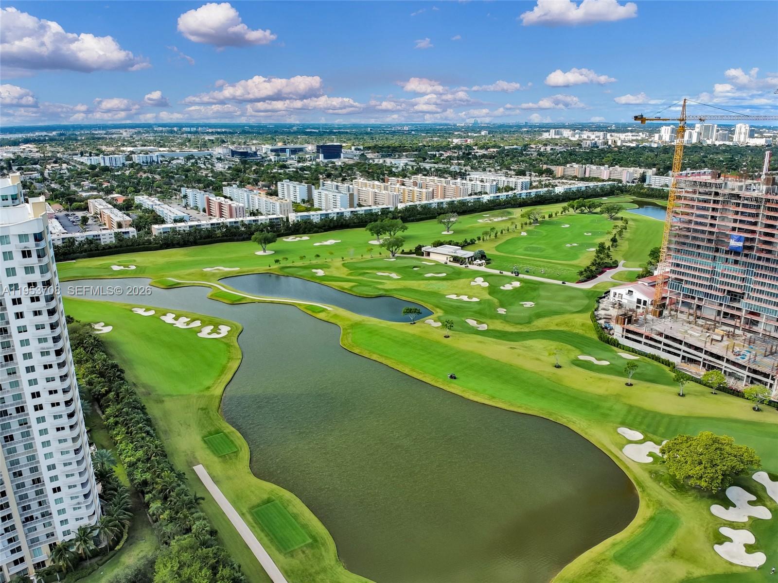 An aerial view shows a golf course with a large pond and surrounding residential buildings — 1755 E Hallandale Beach Blvd # 1208E, Hallandale Beach FL 33009, HALLANDALE BEACH, FL