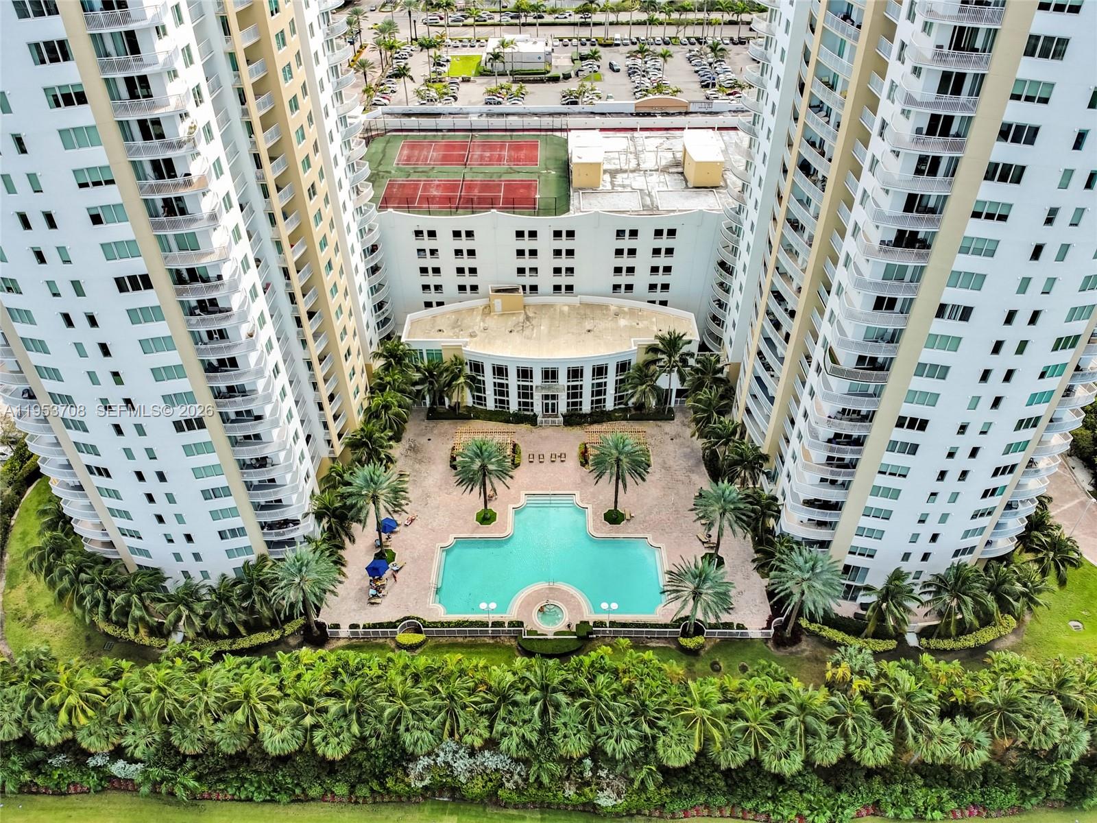 An aerial view shows a swimming pool courtyard between two tall residential apartment buildings — 1755 E Hallandale Beach Blvd # 1208E, Hallandale Beach FL 33009, HALLANDALE BEACH, FL