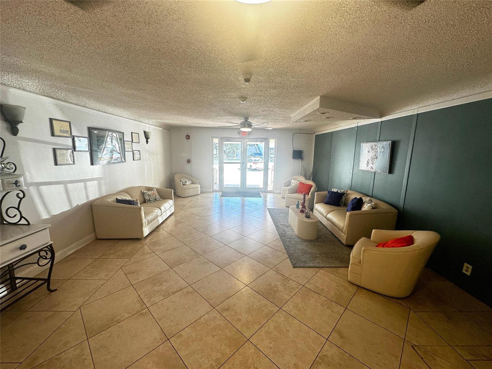 A lobby features beige tile floors, two sofas, three armchairs, and a dark green accent wall — 2400 S Ocean Drive # 314, Hollywood FL 33019, HOLLYWOOD, FL