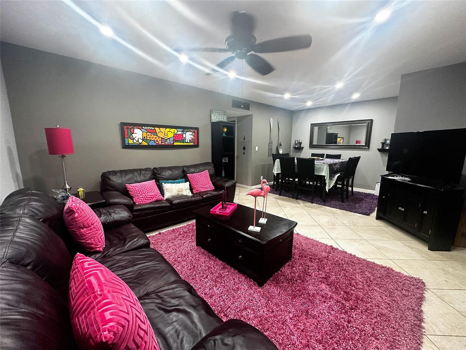 A living and dining room features dark leather furniture, a pink rug, and tile flooring — 2400 S Ocean Drive # 314, Hollywood FL 33019, HOLLYWOOD, FL