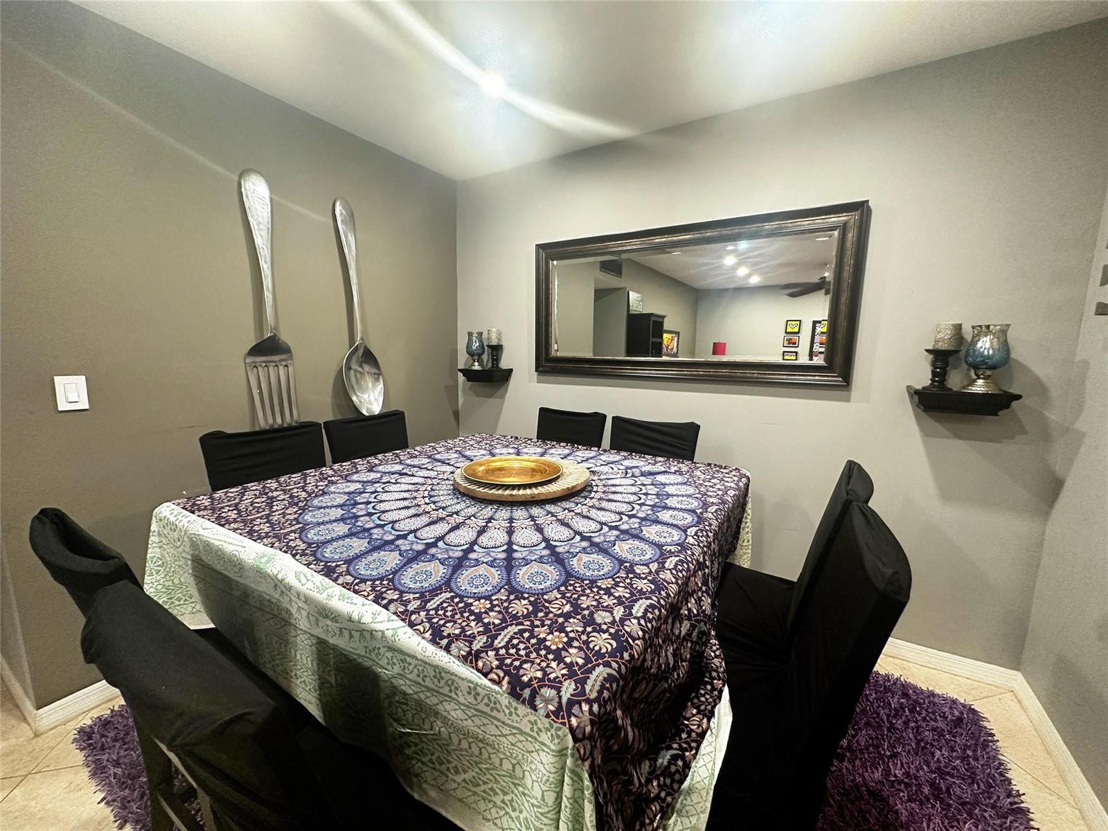 A dining room features a square table with a patterned cloth, black chairs, and wall decor — 2400 S Ocean Drive # 314, Hollywood FL 33019, HOLLYWOOD, FL
