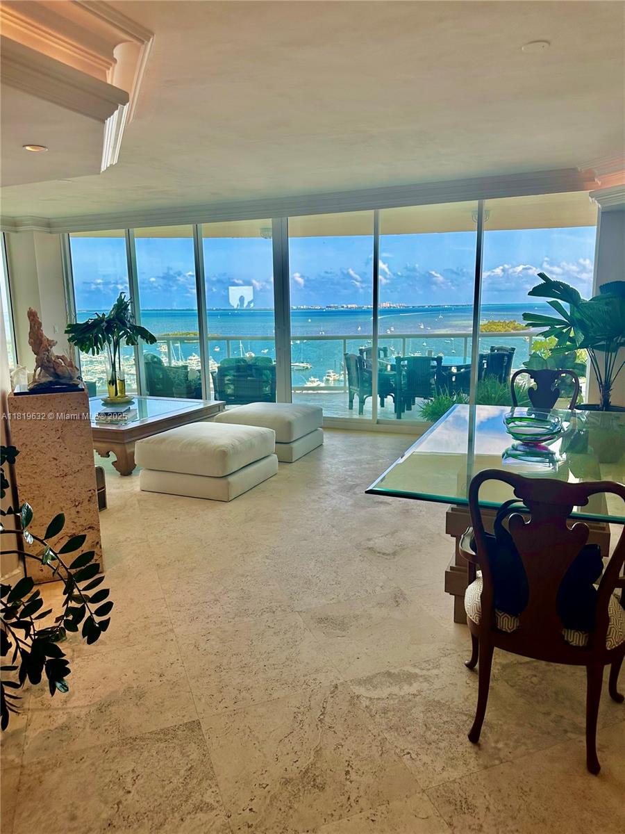 A bright living and dining area features floor-to-ceiling windows overlooking a bay with boats — 2645 S Bayshore Dr # 1403, Miami FL 33133, MIAMI, FL