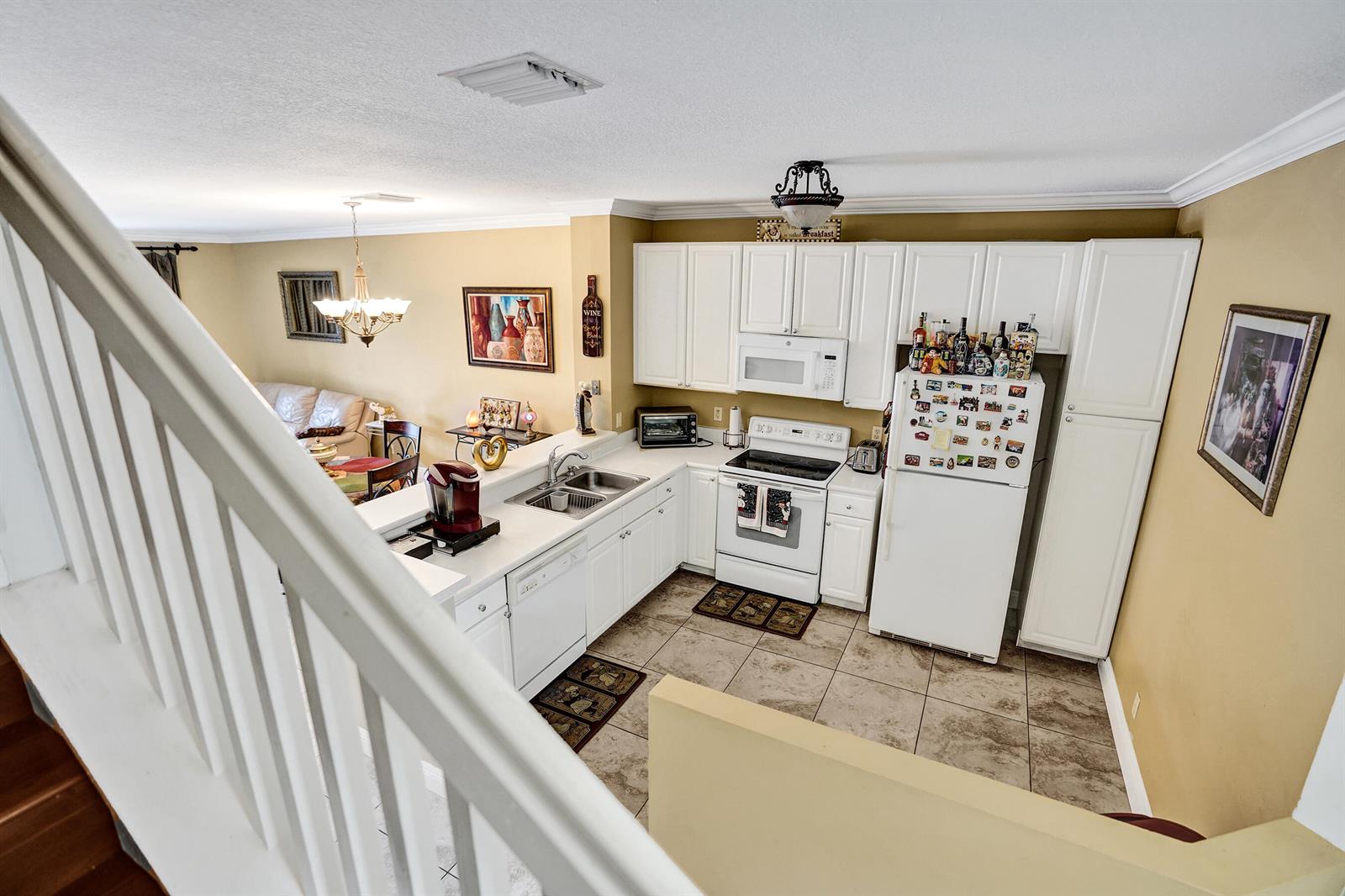 A high-angle view shows a kitchen with white cabinets, white appliances, and tiled flooring — 9664 Porta Leona Lane, Boynton Beach FL 33472, BOYNTON BEACH, FL