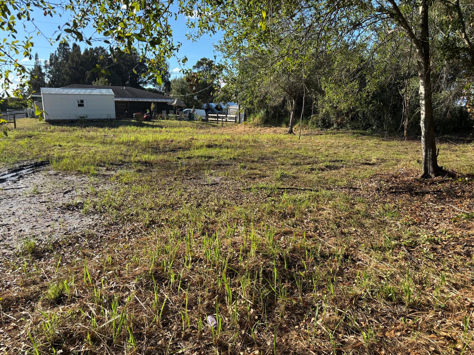 A grassy, partially muddy lot with a small white building in the background — 2897 NW 32nd Avenue, Okeechobee FL 34972, OKEECHOBEE, FL