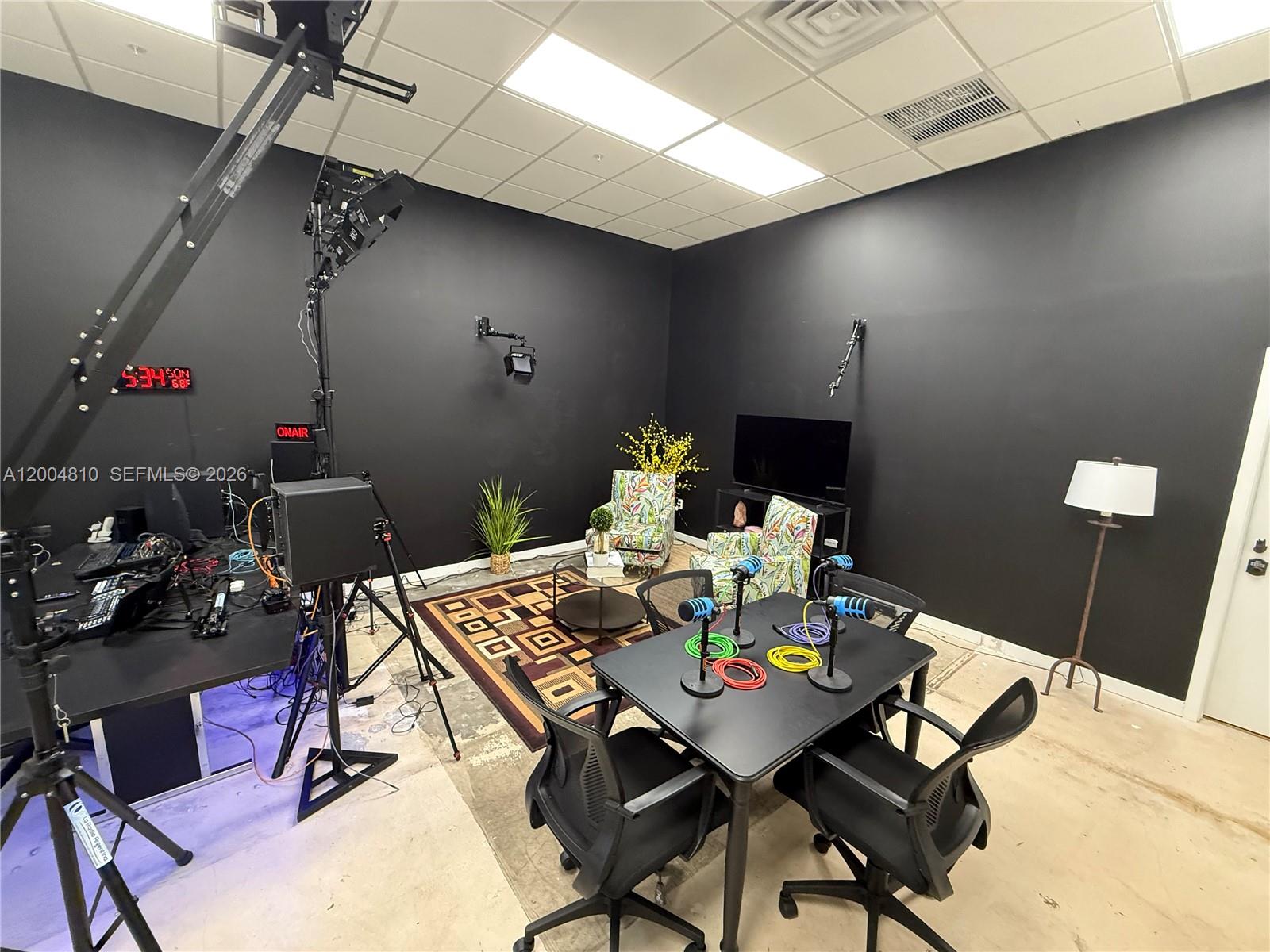 This podcast studio features a black-walled room with a recording table, microphones, and equipment — 7445 W 4th Ave Unit 102, Hialeah FL 33014, HIALEAH, FL