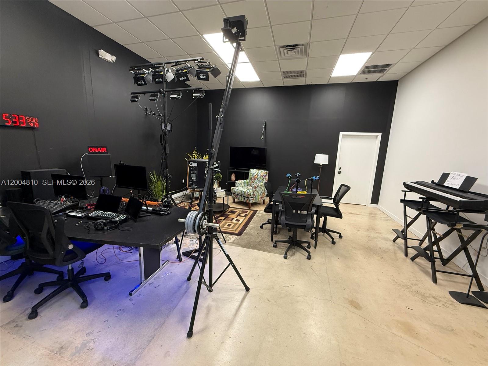 A studio room features black walls, professional lighting equipment, a desk, and a keyboard stand — 7445 W 4th Ave Unit 102, Hialeah FL 33014, HIALEAH, FL