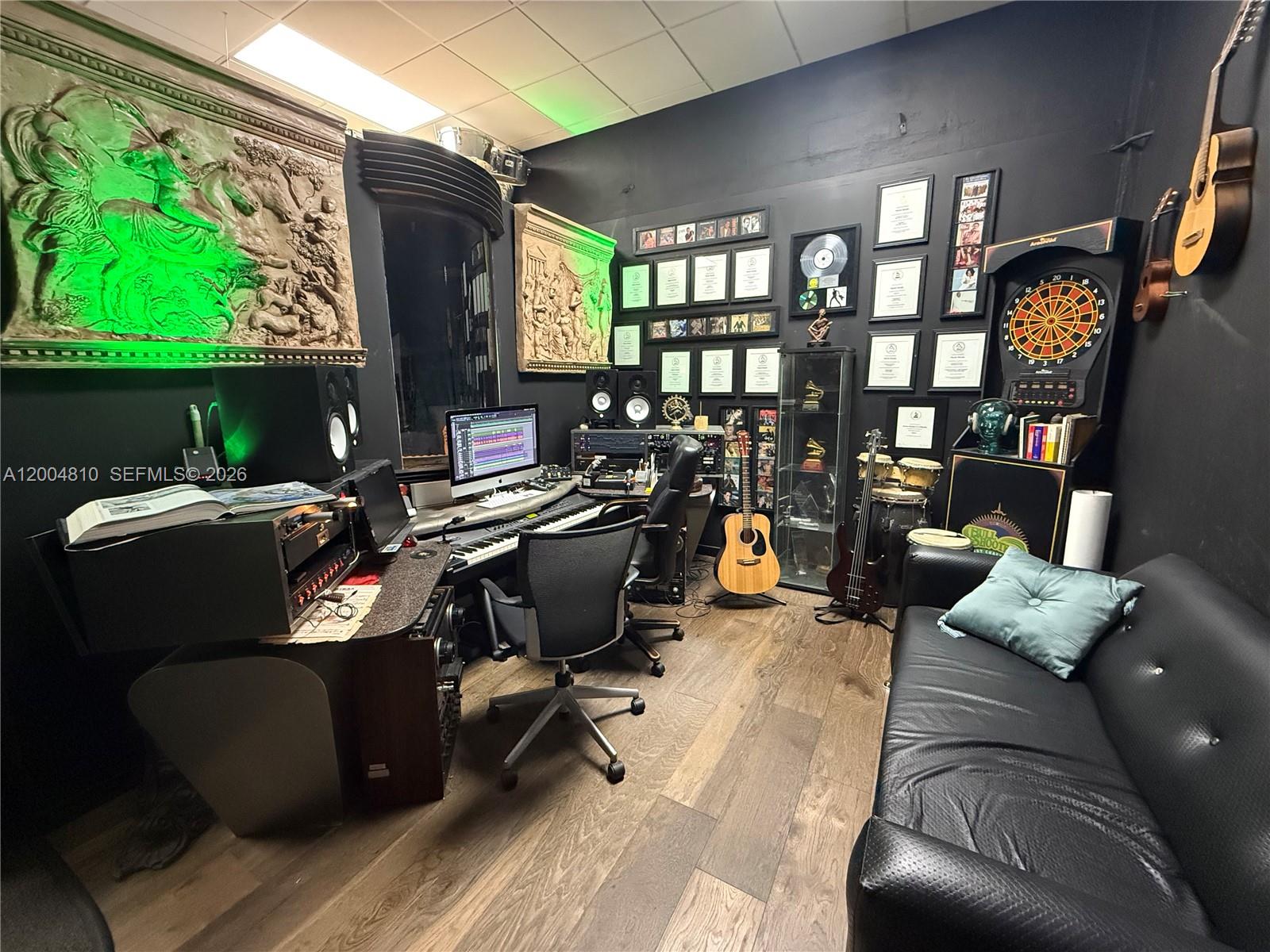 A music recording studio features a desk with computer equipment, musical instruments, and a sofa — 7445 W 4th Ave Unit 102, Hialeah FL 33014, HIALEAH, FL
